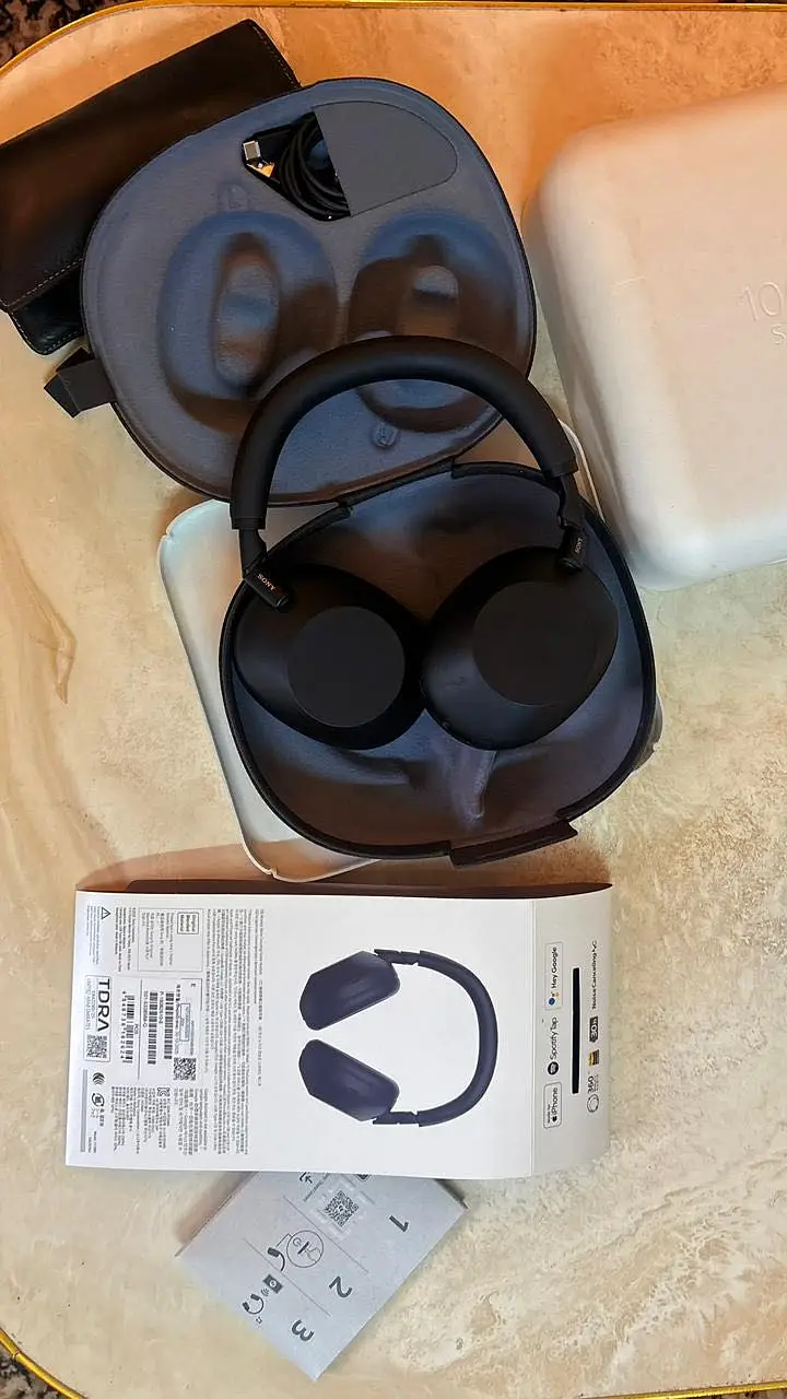 Sony WF-1000XM6 charging case open, showing the physical reset button on the back panel.