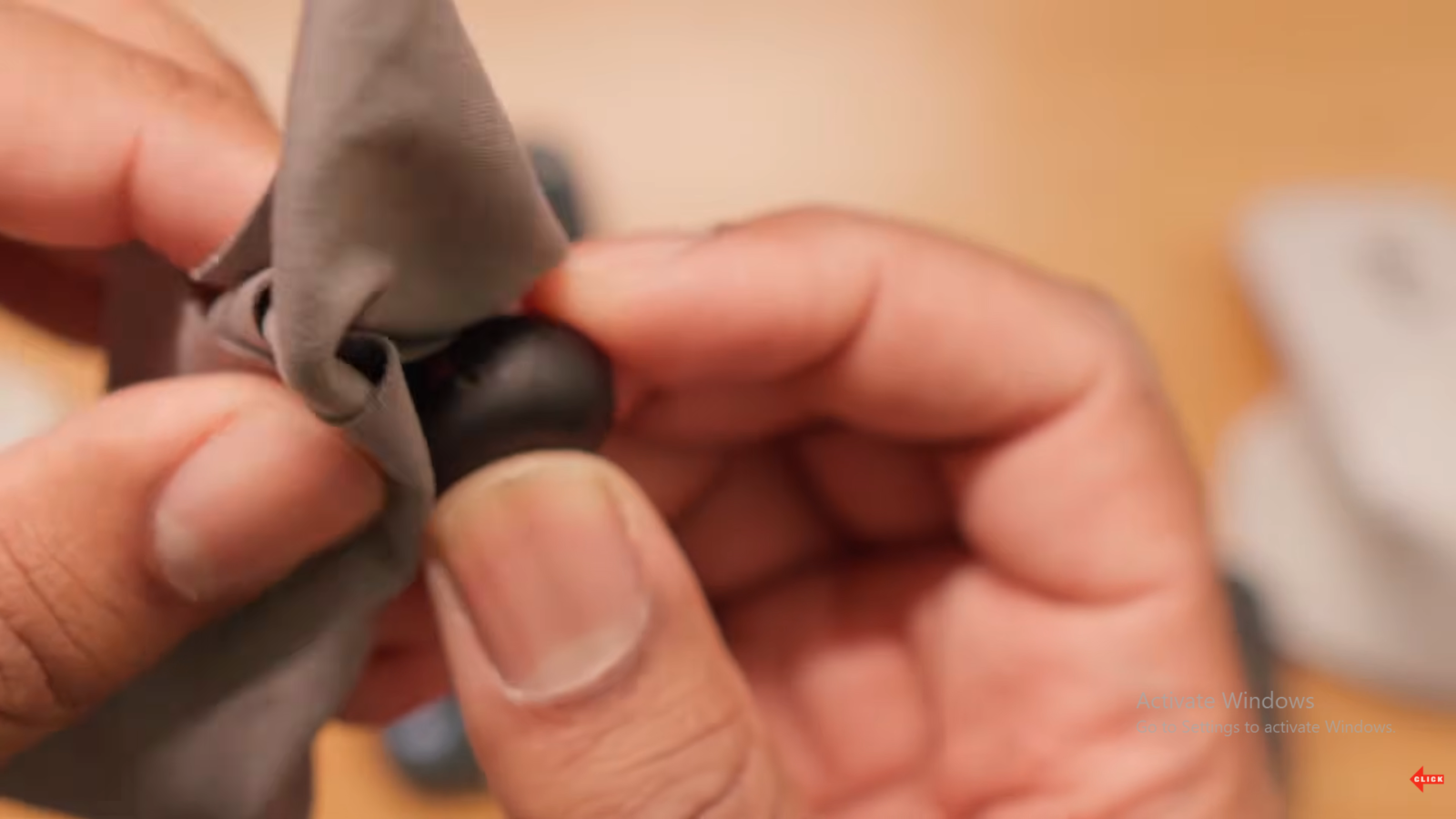 A dry cloth being used to clean the Sony WF-1000XM6 foam ear tips.