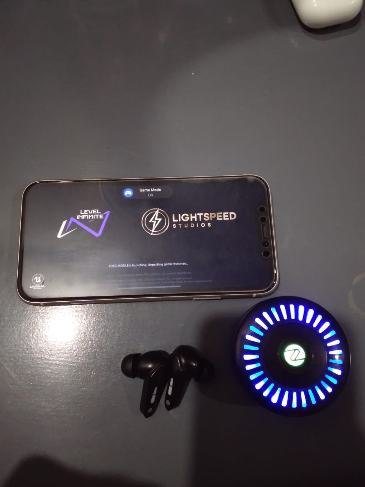 Zero Arcade 900 earbuds next to a smartphone running PUBG Mobile on Erangel.